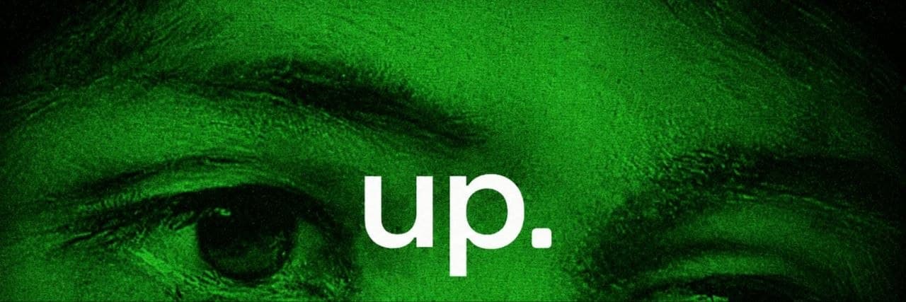 Close-up of an eye in green tones with the word "up."